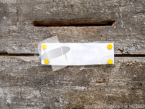 Image of mailbox slot on a wooden door with white paper