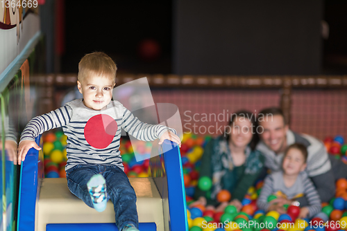 Image of parents and kids playing in the pool with colorful balls