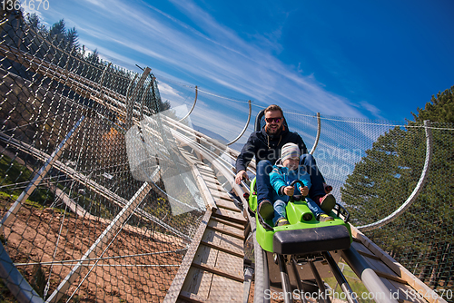 Image of young father and son driving alpine coaster