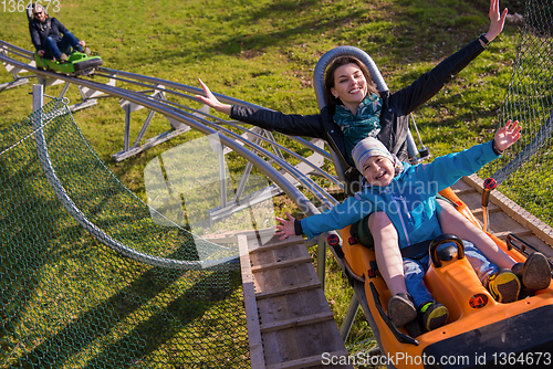 Image of young mother and son driving alpine coaster