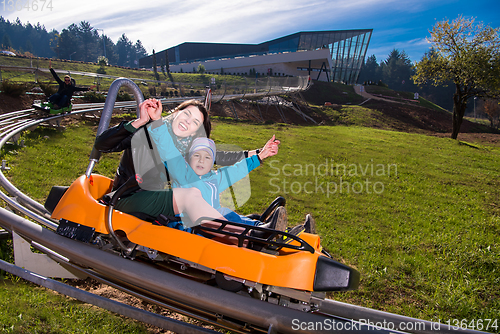 Image of young mother and son driving alpine coaster