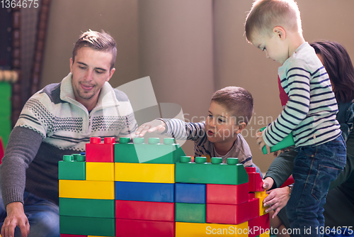 Image of young parents and kids having fun at childrens playroom