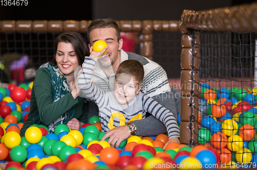 Image of parents and kids playing in the pool with colorful balls