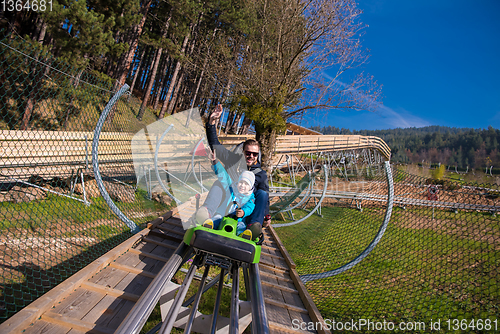 Image of young father and son driving alpine coaster