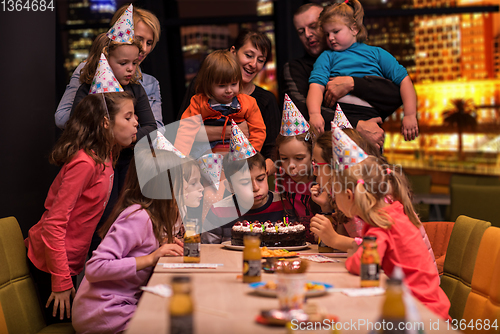 Image of happy young boy having birthday party