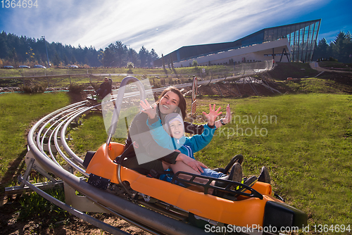 Image of young mother and son driving alpine coaster