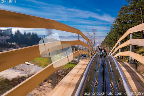 Image of young father and son driving alpine coaster