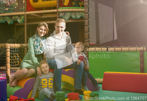 Image of young parents and kids having fun at childrens playroom