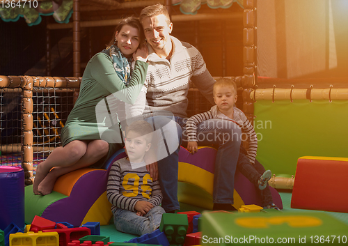 Image of young parents and kids having fun at childrens playroom