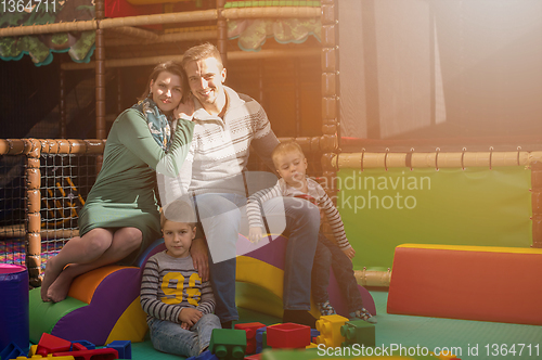 Image of young parents and kids having fun at childrens playroom