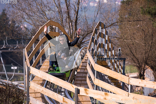 Image of young father and son driving alpine coaster