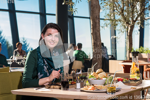 Image of young woman  having lunch at restaurant