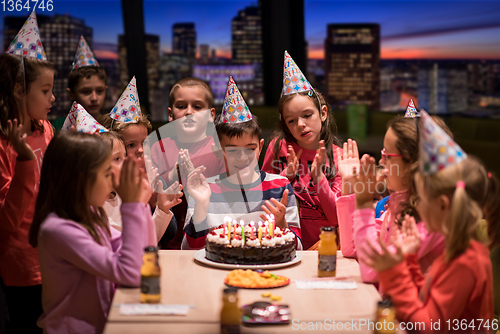Image of happy young boy having birthday party