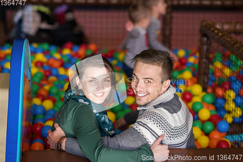 Image of parents and kids playing in the pool with colorful balls