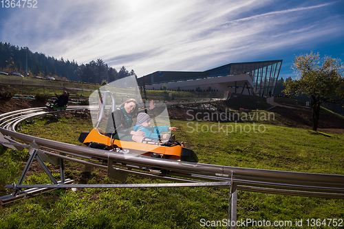 Image of young mother and son driving alpine coaster