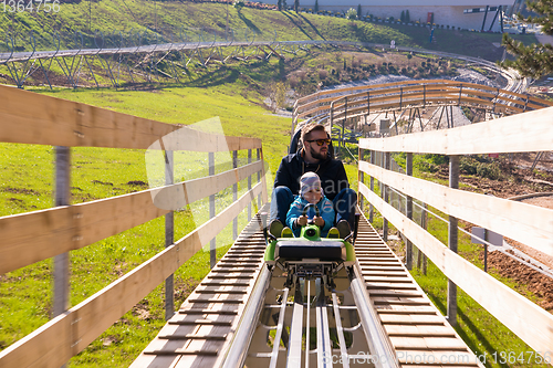 Image of young father and son driving alpine coaster