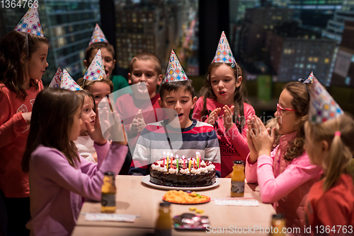 Image of happy young boy having birthday party
