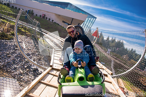 Image of young father and son driving alpine coaster