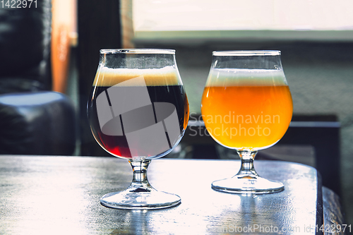 Image of Glasses of different kinds of beer on wooden background