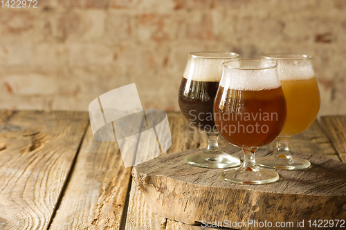 Image of Glasses of different kinds of beer on wooden background