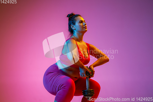 Image of Young caucasian plus size female model\'s training on gradient background