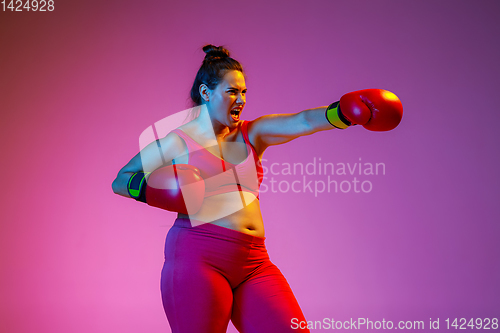 Image of Young caucasian plus size female model\'s training on gradient background