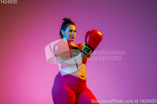 Image of Young caucasian plus size female model\'s training on gradient background