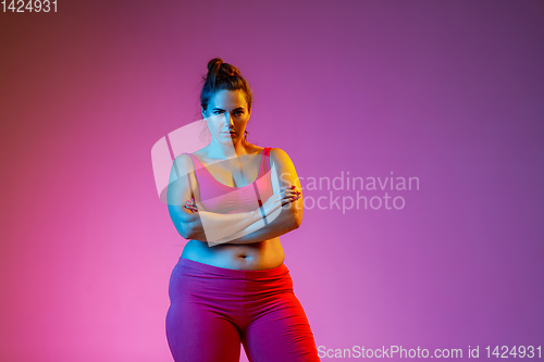Image of Young caucasian plus size female model\'s training on gradient background