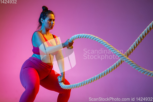 Image of Young caucasian plus size female model\'s training on gradient background