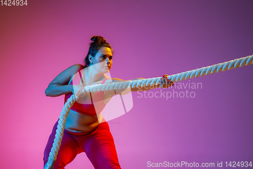 Image of Young caucasian plus size female model\'s training on gradient background