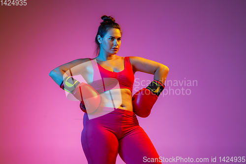 Image of Young caucasian plus size female model\'s training on gradient background