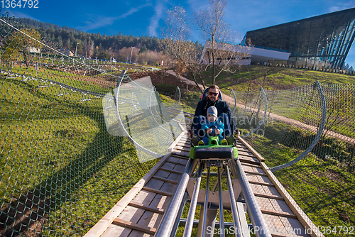 Image of young father and son driving alpine coaster