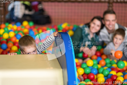 Image of parents and kids playing in the pool with colorful balls