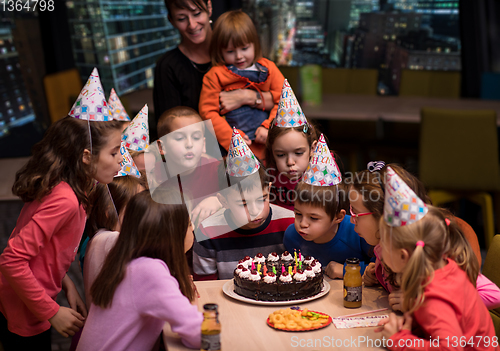 Image of happy young boy having birthday party