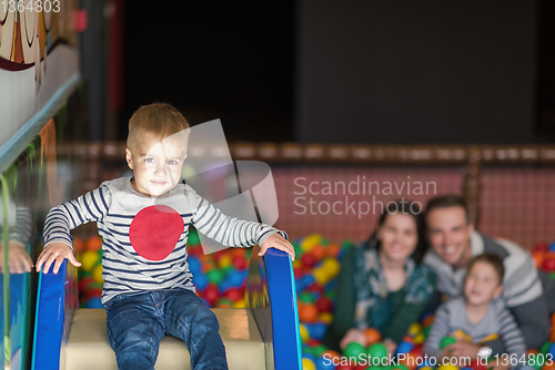 Image of parents and kids playing in the pool with colorful balls