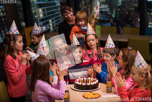 Image of happy young boy having birthday party