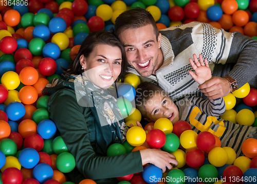 Image of parents and kids playing in the pool with colorful balls