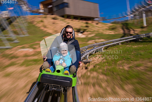 Image of young father and son driving alpine coaster