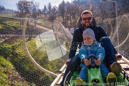 Image of young father and son driving alpine coaster