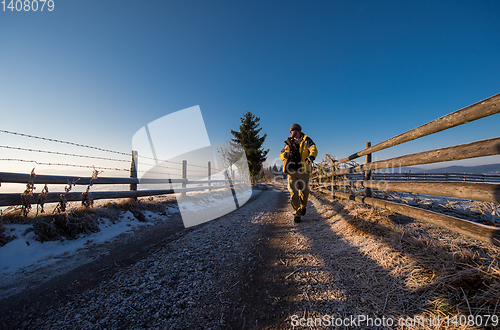 Image of young photographer walking on country road