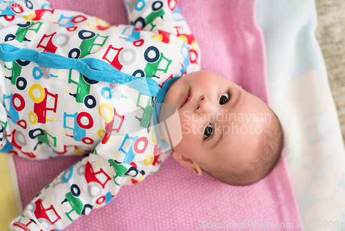 Image of top view of newborn baby boy lying on colorful blankets