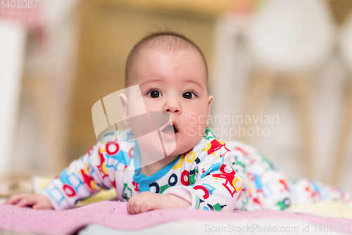 Image of newborn baby boy playing on the floor