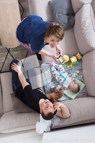 Image of top view of happy mother and father taking picture of baby