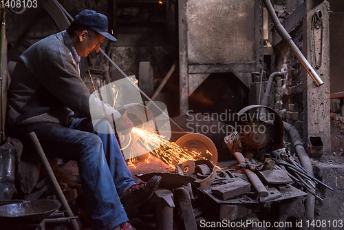 Image of the blacksmith polishing metal products