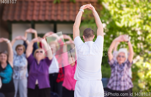 Image of trainer training motivated active healthy senior people