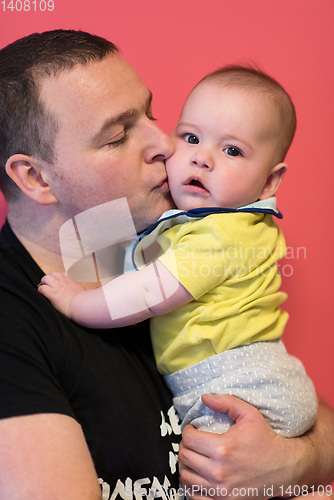 Image of portrait of happy young father holding baby isolated on red
