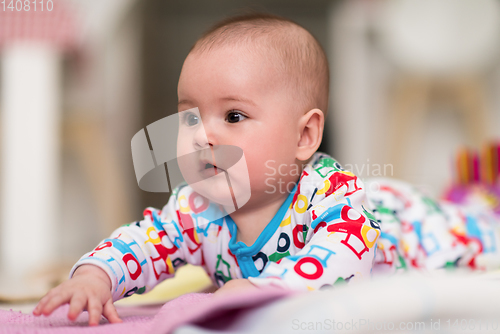 Image of newborn baby boy playing on the floor