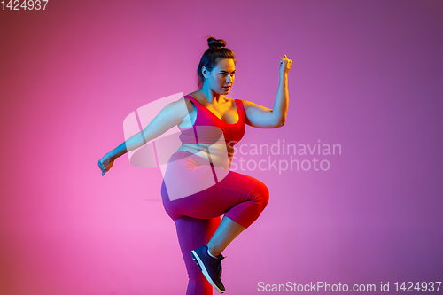 Image of Young caucasian plus size female model\'s training on gradient background