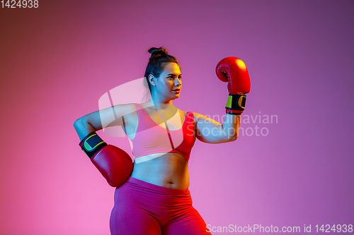 Image of Young caucasian plus size female model\'s training on gradient background