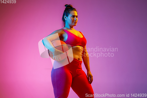 Image of Young caucasian plus size female model\'s training on gradient background